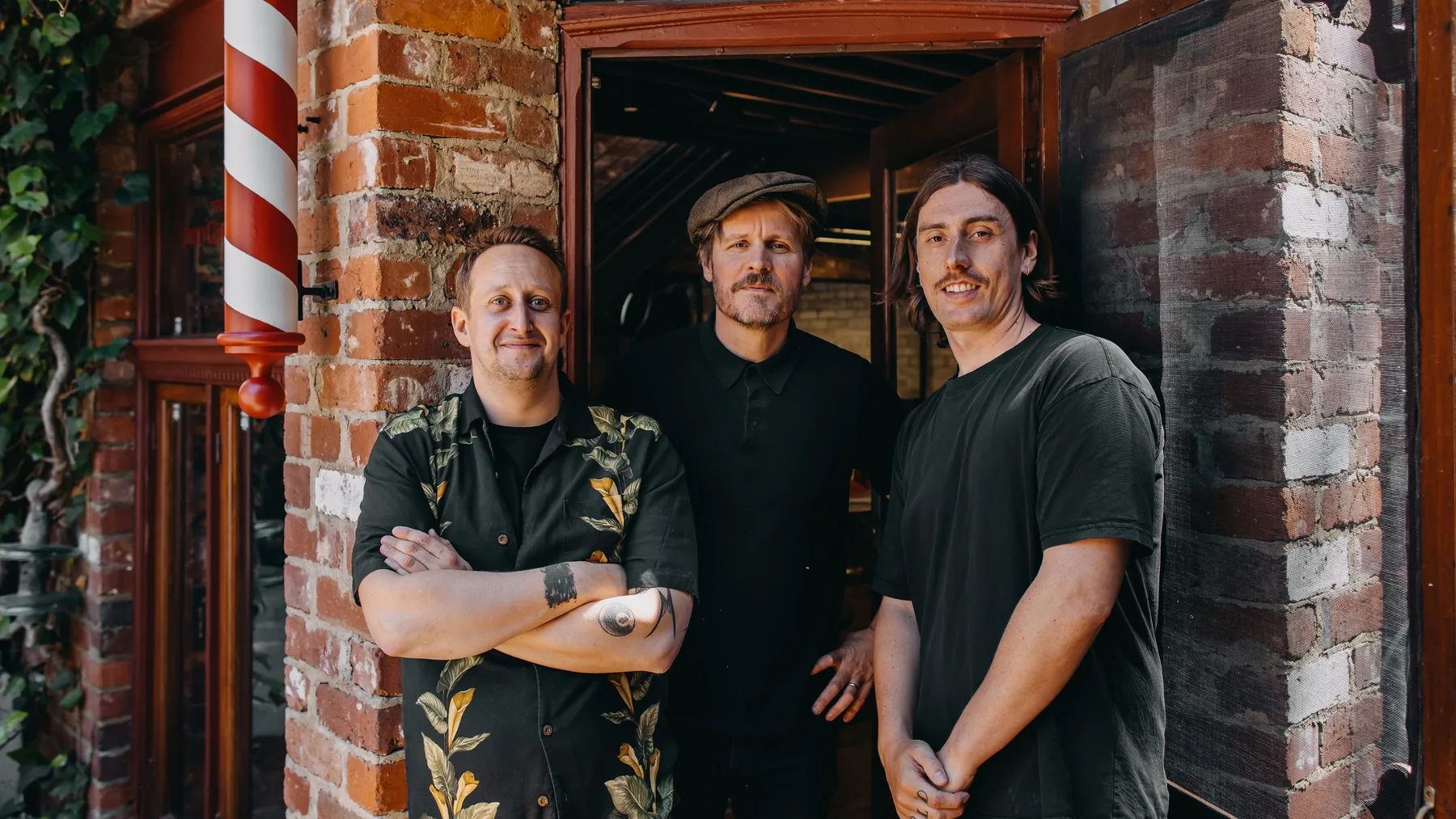 Tommy, Paul and Jack in the doorway of The Two Georges barbershop