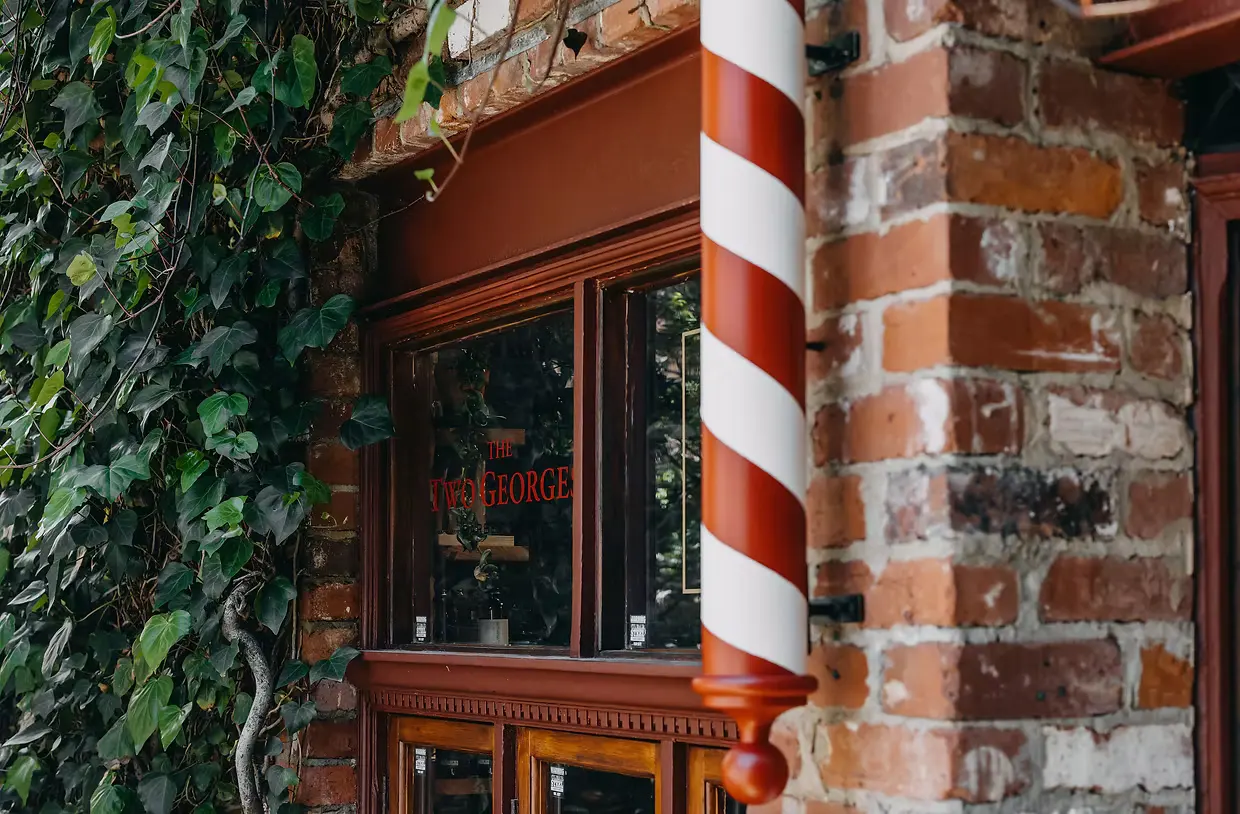 The ivy covered brick archway and barber pole at the entrance to The Two Georges, 16A Bannister Street Fremantle